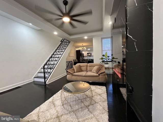 living room with crown molding, a notable chandelier, and a tray ceiling