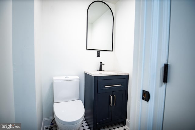 bathroom with toilet, tile patterned floors, and vanity