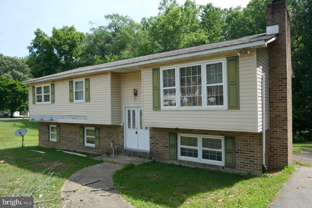 raised ranch featuring a front lawn