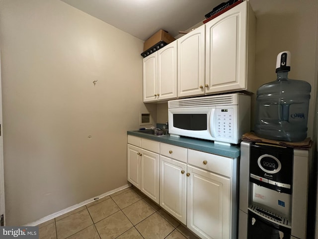 kitchen featuring light tile patterned floors and white cabinets