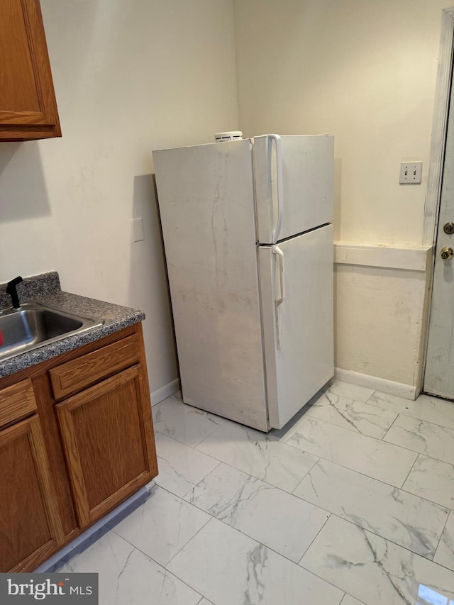 kitchen with sink, light tile patterned flooring, and white refrigerator