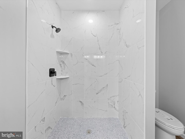 bathroom with toilet and a tile shower