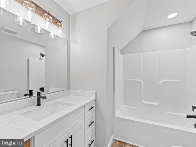 full bathroom featuring wood-type flooring, toilet, vanity, and tub / shower combination