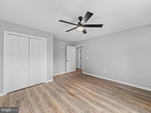 unfurnished bedroom featuring light hardwood / wood-style floors, a closet, and ceiling fan