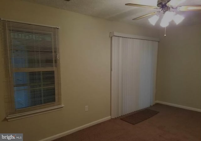 carpeted spare room with ceiling fan and a textured ceiling