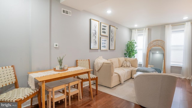 living area with recessed lighting, visible vents, and wood finished floors