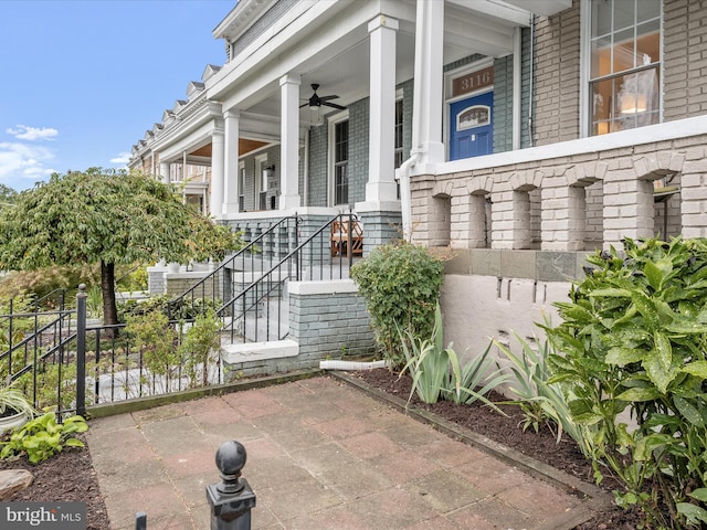 entrance to property featuring covered porch and ceiling fan