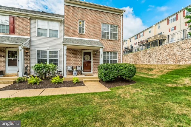 townhome / multi-family property featuring a front lawn