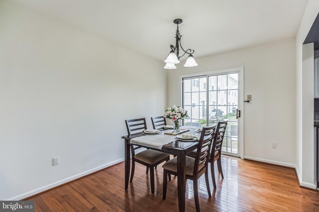 dining room featuring wood-type flooring and a notable chandelier