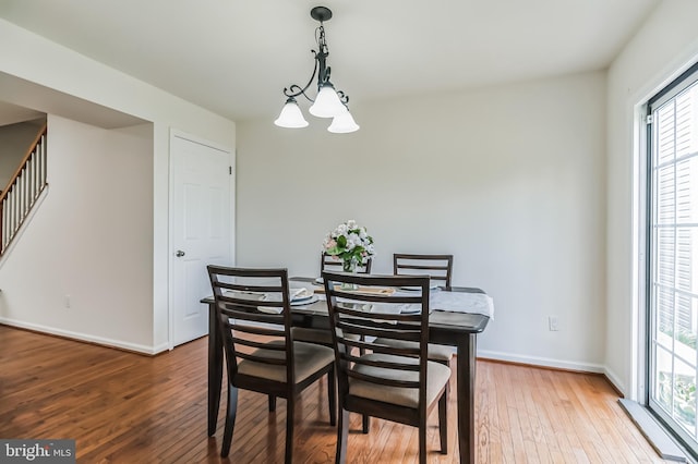 dining area with hardwood / wood-style flooring and a chandelier