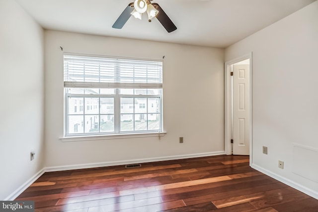 empty room with ceiling fan and dark hardwood / wood-style flooring