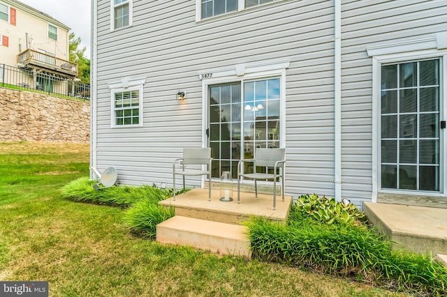 doorway to property with a lawn