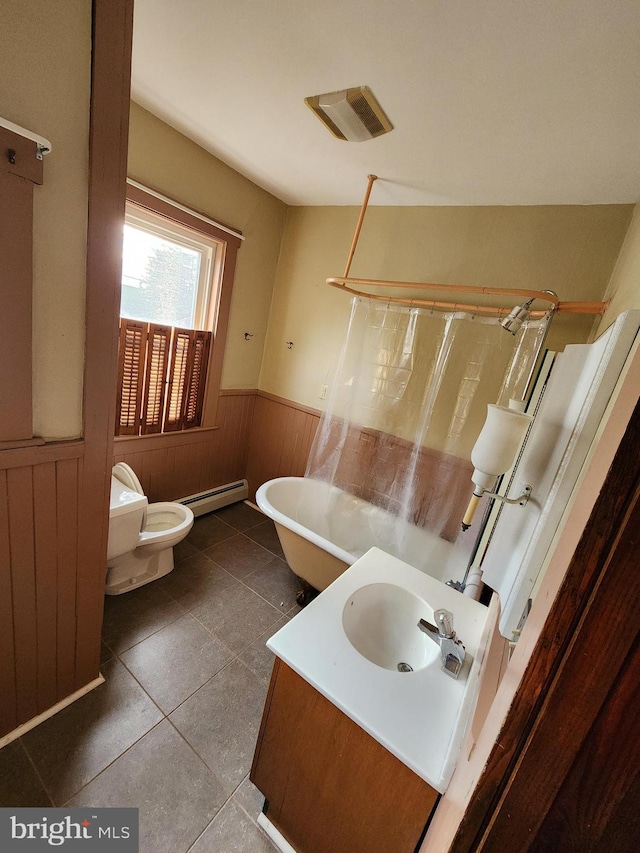 bathroom featuring vanity, toilet, a baseboard heating unit, and tile patterned flooring