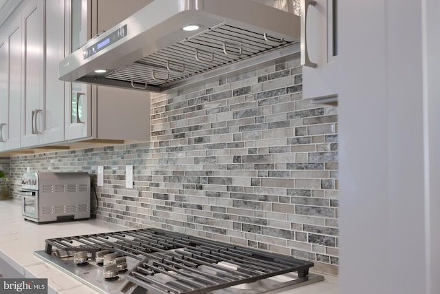 kitchen with decorative backsplash and wall chimney range hood