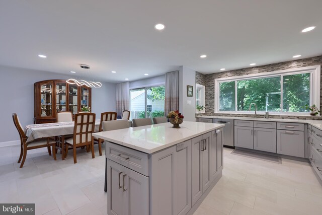 kitchen featuring dishwasher, pendant lighting, a healthy amount of sunlight, and light tile patterned floors