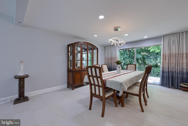 tiled dining room with a notable chandelier