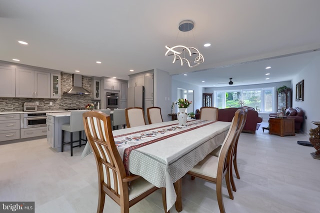 tiled dining room featuring ceiling fan with notable chandelier