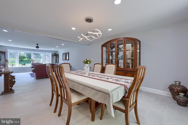 dining area with ceiling fan with notable chandelier and light tile patterned floors