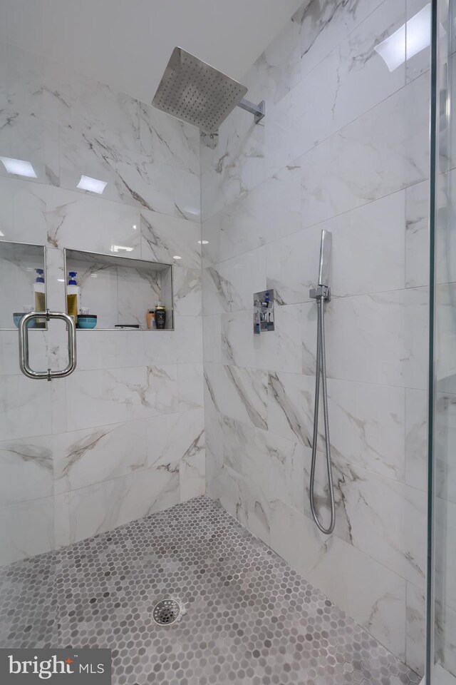 bathroom with a shower with door