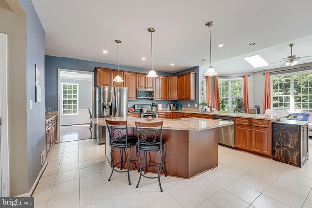 kitchen with sink, plenty of natural light, stainless steel appliances, and a kitchen island