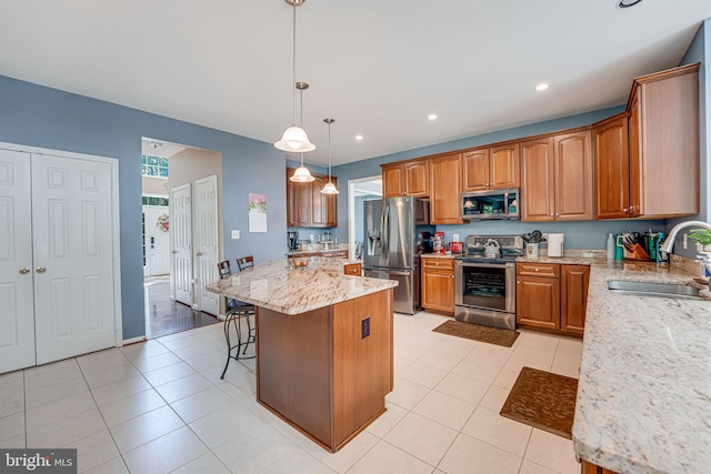 kitchen with appliances with stainless steel finishes, pendant lighting, sink, a center island, and light tile patterned floors