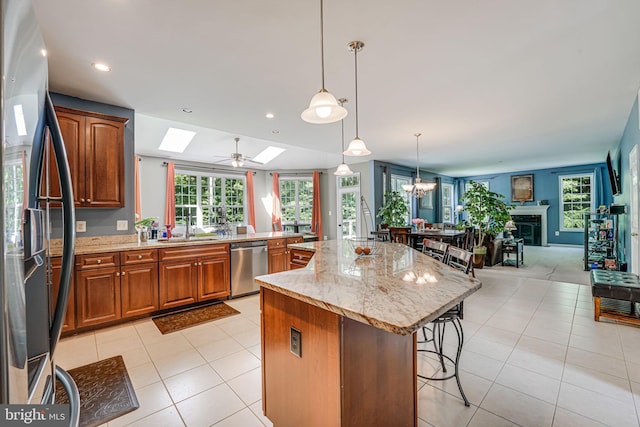 kitchen with a kitchen island, a breakfast bar, pendant lighting, light tile patterned floors, and stainless steel appliances