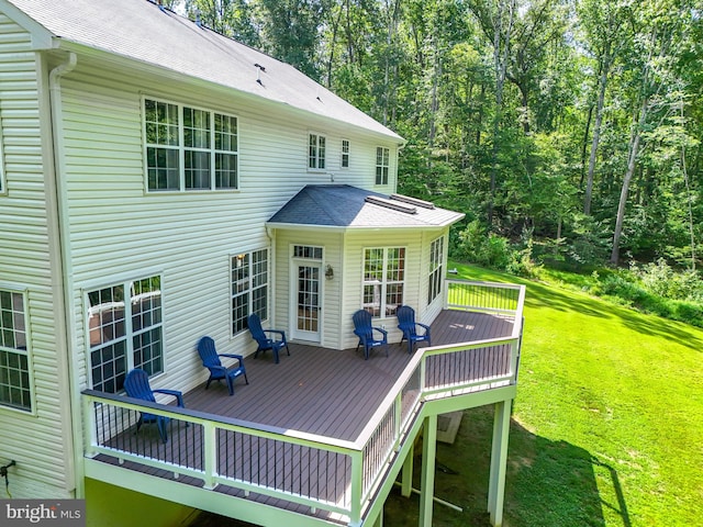 rear view of property with a yard and a deck