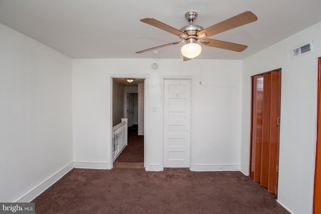 carpeted spare room featuring ceiling fan