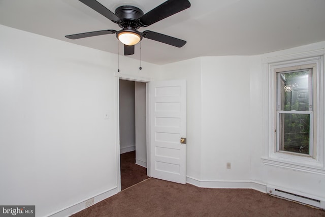 carpeted spare room featuring baseboard heating and ceiling fan