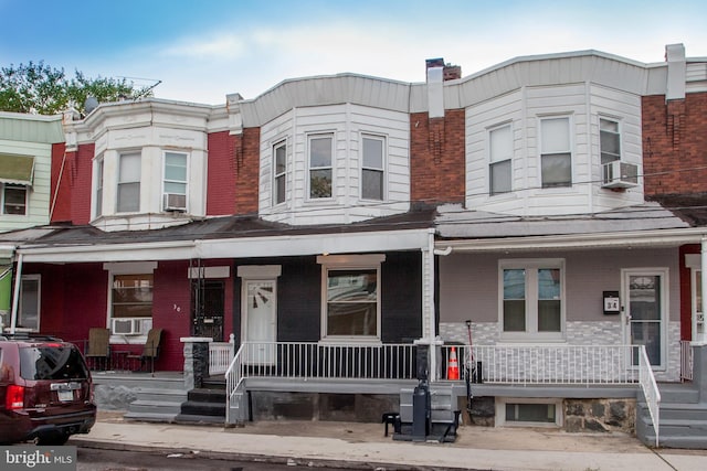 townhome / multi-family property featuring cooling unit and a porch