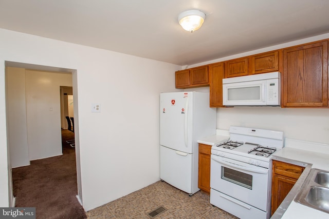 kitchen featuring light colored carpet and white appliances