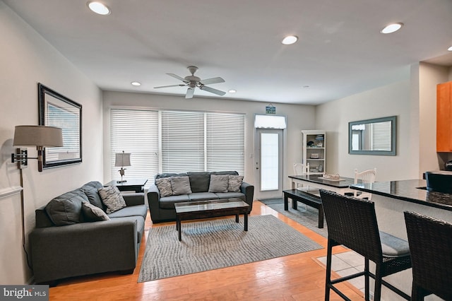 living area featuring light wood finished floors, a ceiling fan, a wealth of natural light, and recessed lighting