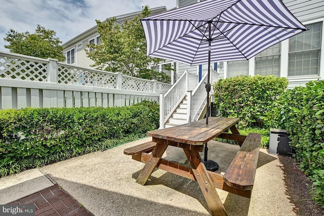 view of patio / terrace featuring stairway and fence