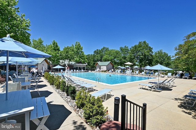 pool with a patio and fence