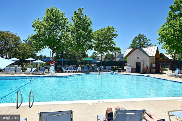 pool with a patio and fence