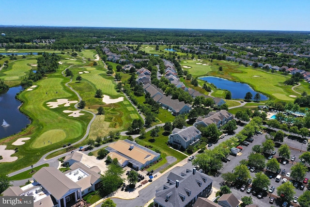 drone / aerial view featuring a residential view, view of golf course, and a water view