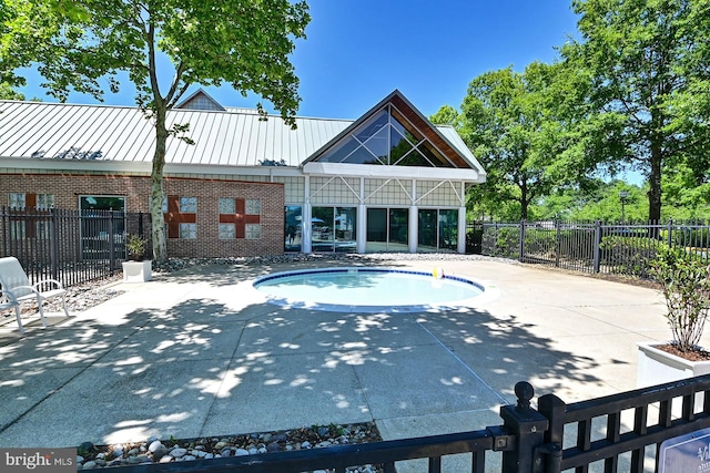 view of pool with a patio area and fence