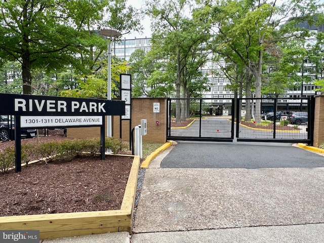 exterior space featuring a gated entry, curbs, and a gate