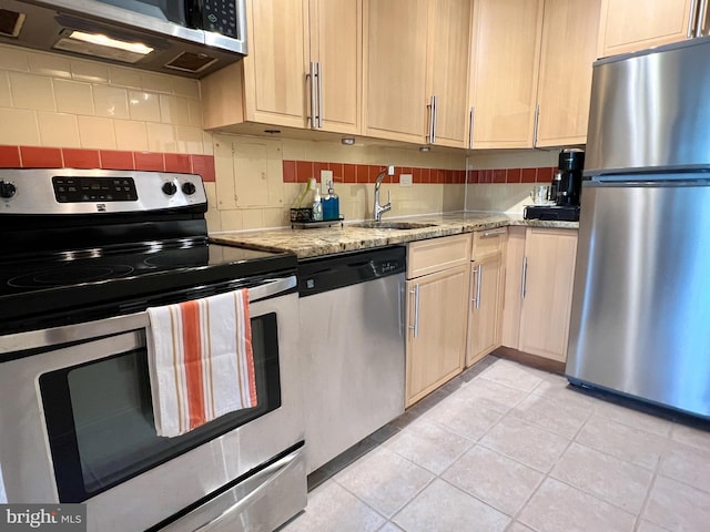 kitchen with light brown cabinetry, light tile patterned floors, backsplash, stainless steel appliances, and sink