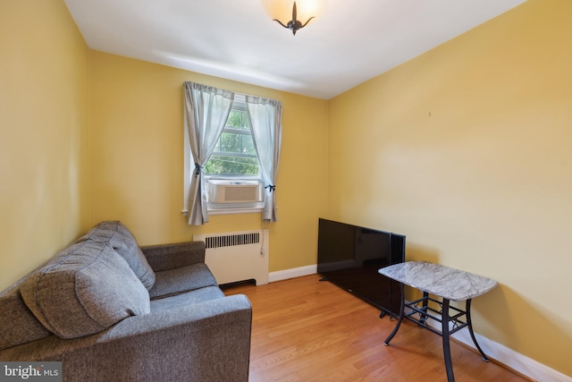 sitting room featuring cooling unit, radiator heating unit, and light hardwood / wood-style floors