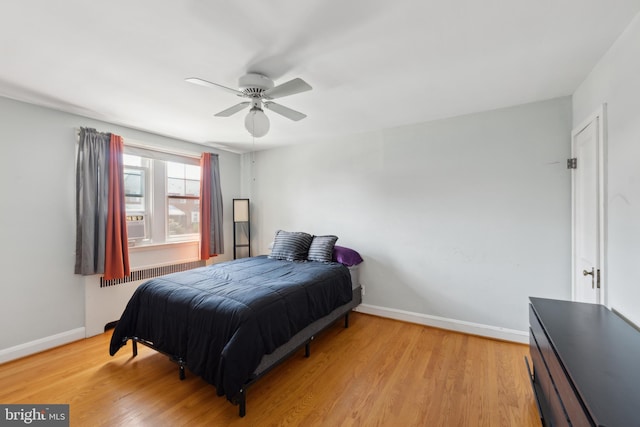 bedroom featuring radiator, ceiling fan, and light wood-type flooring