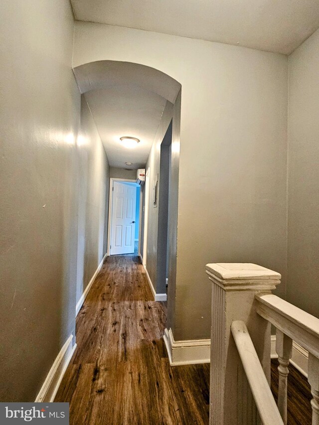 corridor with hardwood / wood-style flooring