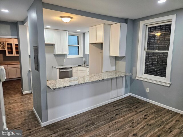 kitchen with kitchen peninsula, white cabinets, dark wood-type flooring, light stone counters, and stainless steel dishwasher