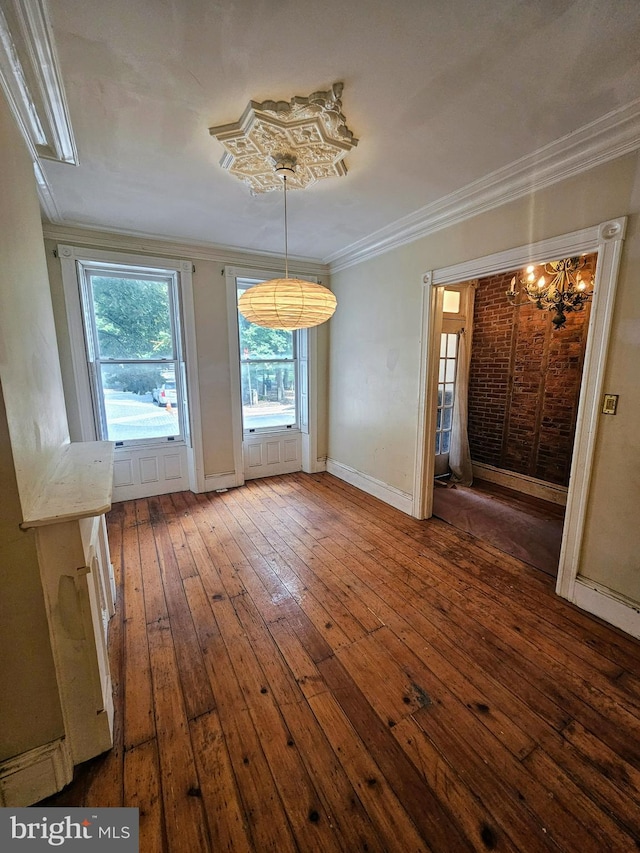 unfurnished room with ornamental molding, hardwood / wood-style floors, and an inviting chandelier