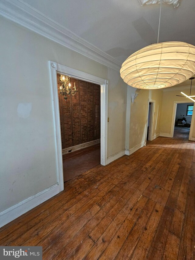 interior space featuring crown molding, hardwood / wood-style floors, and an inviting chandelier