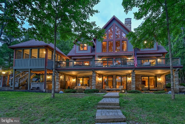 rear view of house with a yard, a chimney, and outdoor lounge area