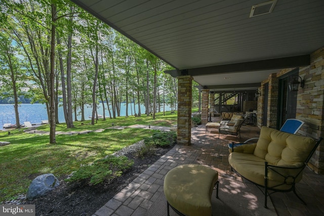 view of patio featuring a water view and an outdoor living space