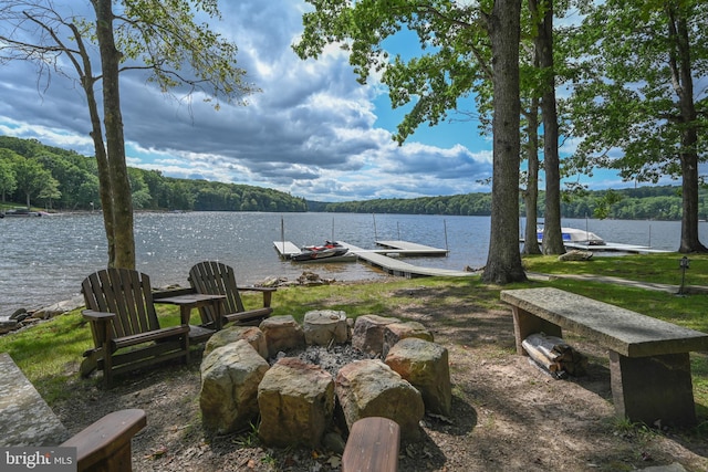 exterior space featuring a dock, a water view, and a view of trees