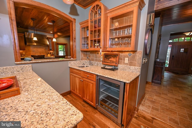 kitchen with decorative backsplash, wood ceiling, wall chimney exhaust hood, beverage cooler, and decorative light fixtures