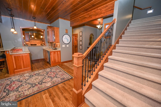 stairway featuring wooden ceiling and hardwood / wood-style flooring